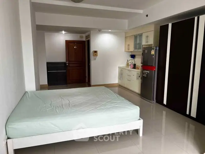 Spacious studio apartment with modern kitchen and ample storage space.