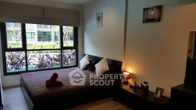 Cozy bedroom with large window and modern decor in a stylish apartment.