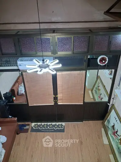 Charming vintage interior with wooden flooring and unique lighting fixture, perfect for cozy living.