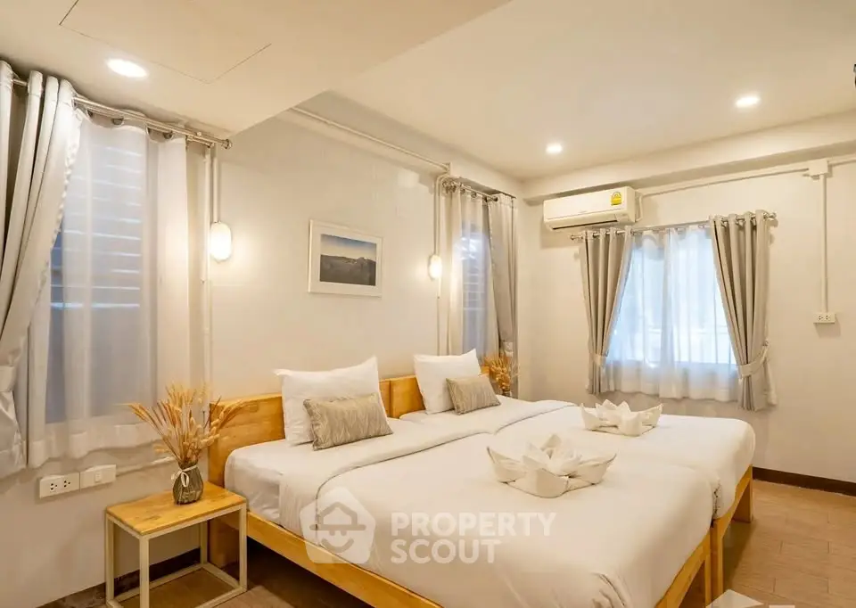 Spacious bedroom with twin beds and elegant decor in modern apartment