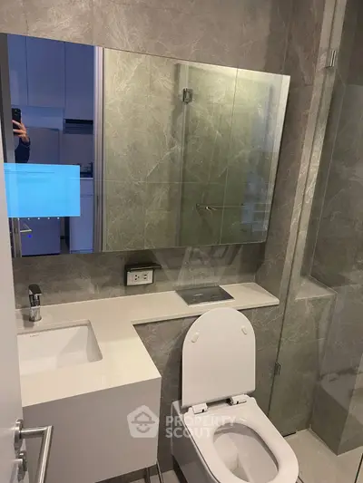 Modern bathroom with sleek design and glass shower enclosure in a contemporary apartment.