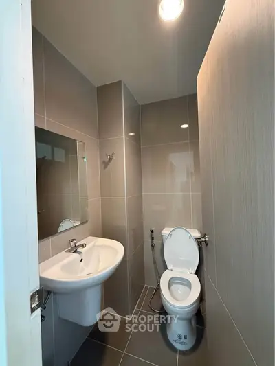 Modern bathroom with sleek fixtures and neutral tiles, perfect for a contemporary home.