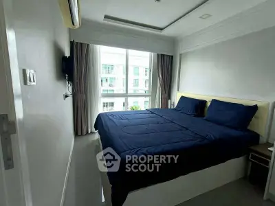 Modern bedroom with large window and stylish blue bedding in a high-rise apartment.
