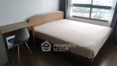 Cozy bedroom with wooden furniture and city view, perfect for urban living.