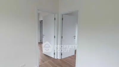 Modern interior with white doors and wooden flooring in a bright hallway