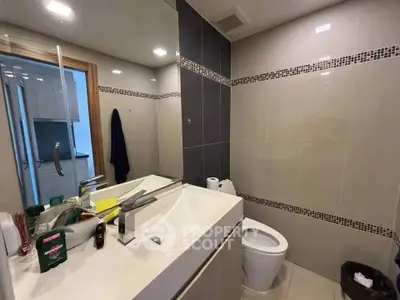 Modern bathroom with sleek fixtures and large mirror in contemporary apartment.