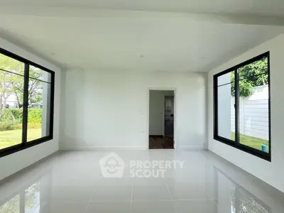 Spacious empty room with large windows and garden view, perfect for customization.