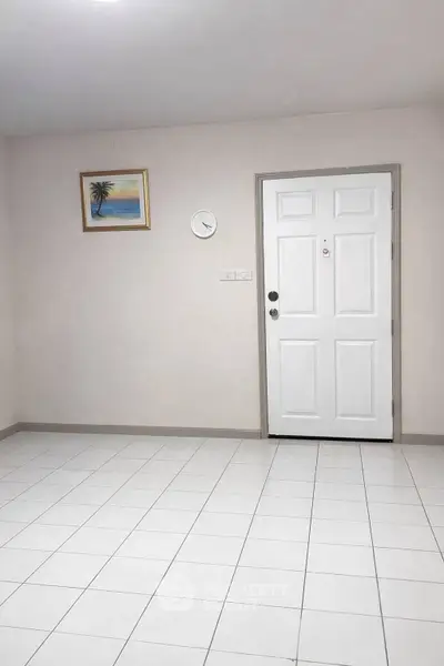 Minimalist interior with white door and tiled floor, perfect for modern living.
