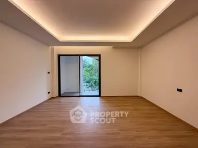 Spacious modern living room with wooden flooring and balcony view