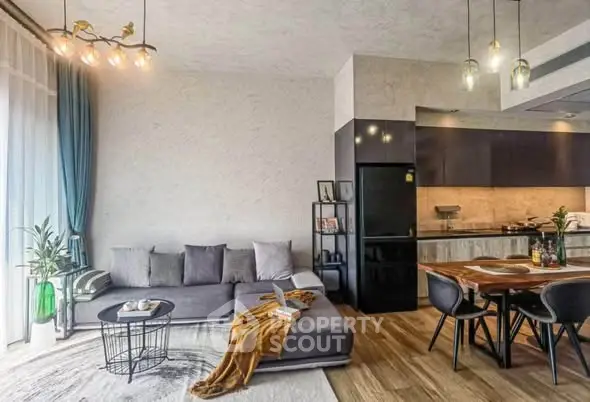 Modern living room with stylish decor and open kitchen layout, featuring a cozy sofa and elegant dining area.