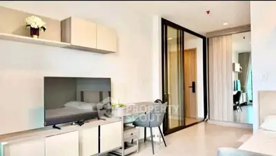 Modern living room with sleek furniture and large TV in a stylish apartment.