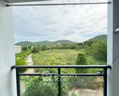 Scenic balcony view overlooking lush greenery and distant hills, perfect for nature lovers.