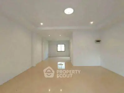 Spacious empty room with tiled flooring and bright lighting, ideal for customization.
