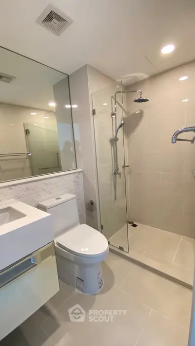 Modern bathroom with glass shower and sleek fixtures in a contemporary home.