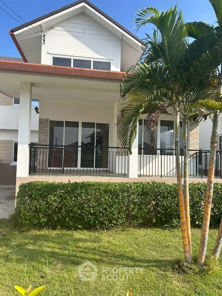 Charming two-story house with lush garden and modern facade, perfect for family living.