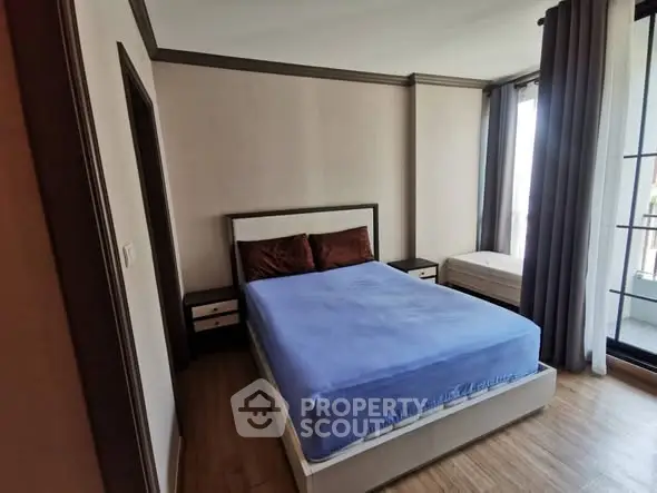 Cozy bedroom with modern decor and large windows for natural light.