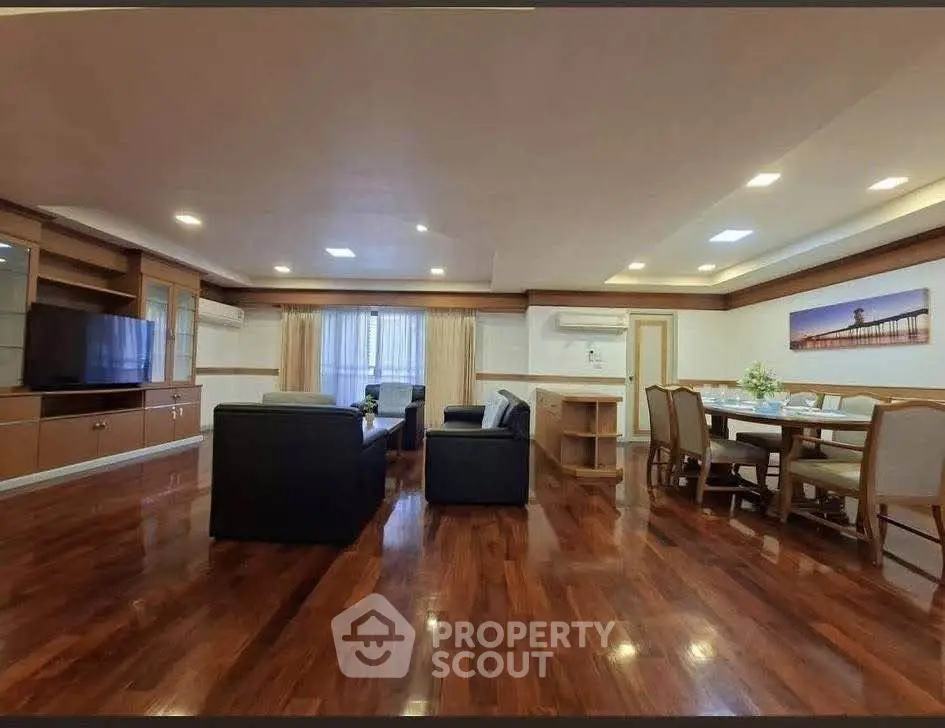 Spacious living room with polished wooden floors and elegant dining area
