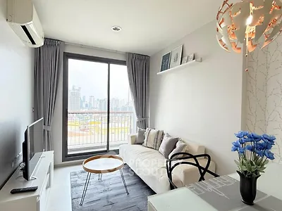 Modern living room with city view, stylish decor, and natural light.