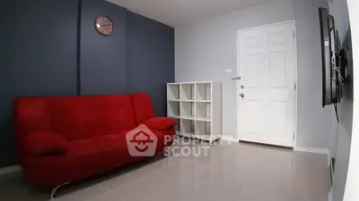 Modern living room with red sofa and sleek white shelving unit.