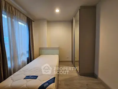 Cozy bedroom with single bed and mirrored wardrobe, perfect for minimalist living.