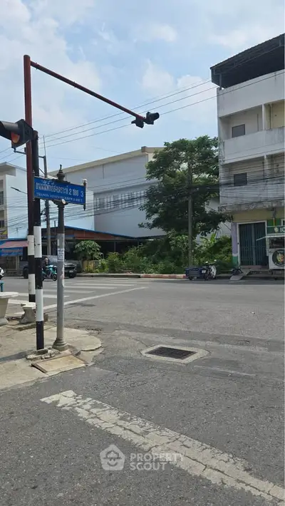 Street view of urban area with buildings and traffic lights, showcasing potential real estate opportunities.
