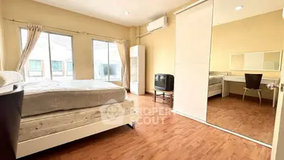 Spacious bedroom with large windows and mirrored closet in modern apartment