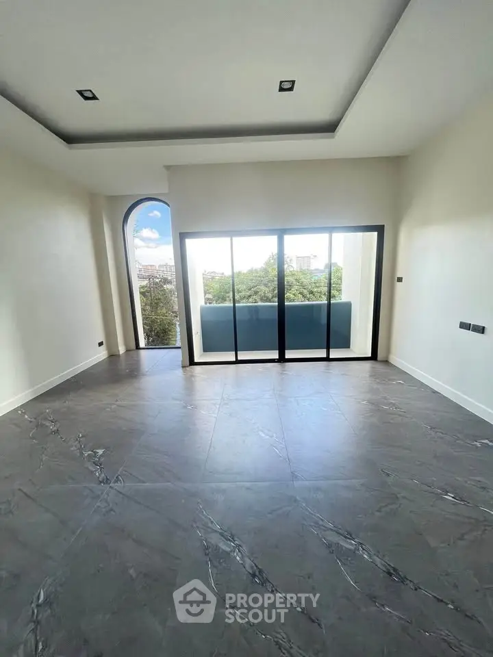 Spacious modern living room with large windows and balcony view