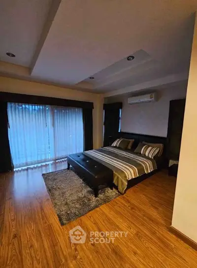 Spacious bedroom with modern decor and wooden flooring