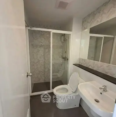 Modern bathroom with sleek shower and elegant fixtures in a contemporary apartment.