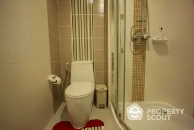 Modern bathroom with shower and toilet in stylish tiled design