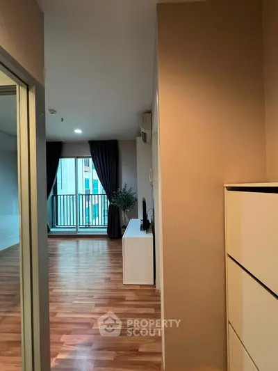 Modern apartment interior with wooden flooring and balcony view
