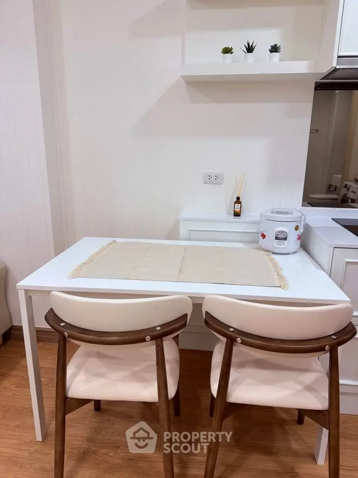 Cozy kitchen with modern dining area and sleek white cabinetry.
