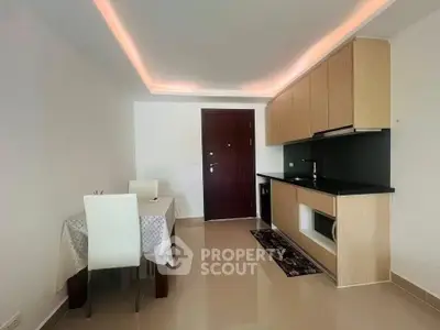 Modern kitchen with sleek cabinetry and dining area in contemporary apartment