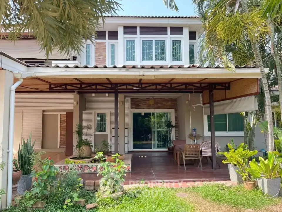 Charming two-story house with spacious patio and lush garden, perfect for outdoor relaxation and entertaining.