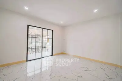 Spacious empty room with marble flooring and large window offering natural light.