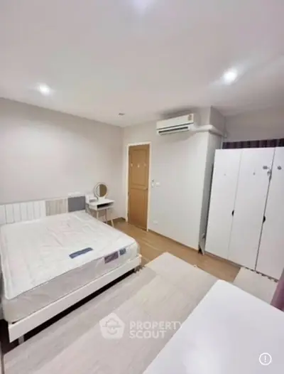 Spacious bedroom with modern furniture and ample storage in a stylish apartment.