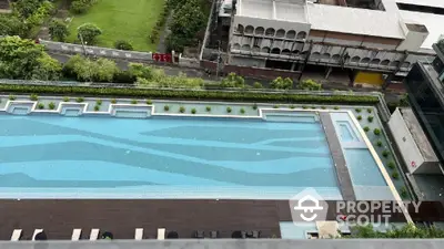 Stunning aerial view of luxurious rooftop swimming pool with lush greenery and cityscape backdrop.