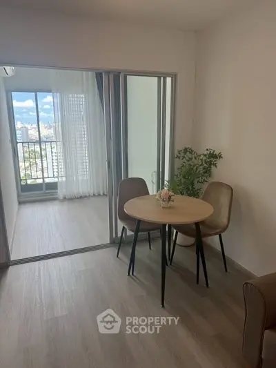 Modern apartment with open layout and balcony view, featuring stylish dining area and natural light.