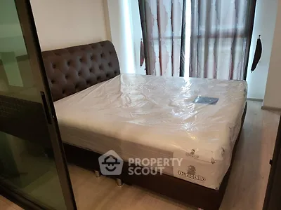 Cozy bedroom with large bed and natural light from window, perfect for relaxation.