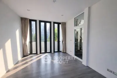 Spacious modern living room with large windows and elegant flooring