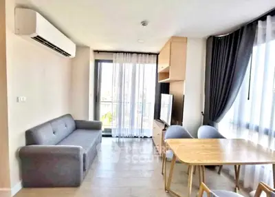 Modern living room with sleek furniture and large windows offering natural light.