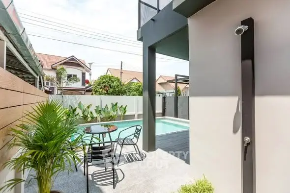 Modern outdoor patio with pool and shower, perfect for relaxation and entertaining.