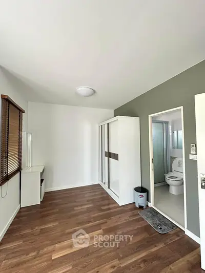 Modern bedroom with ensuite bathroom and wooden flooring