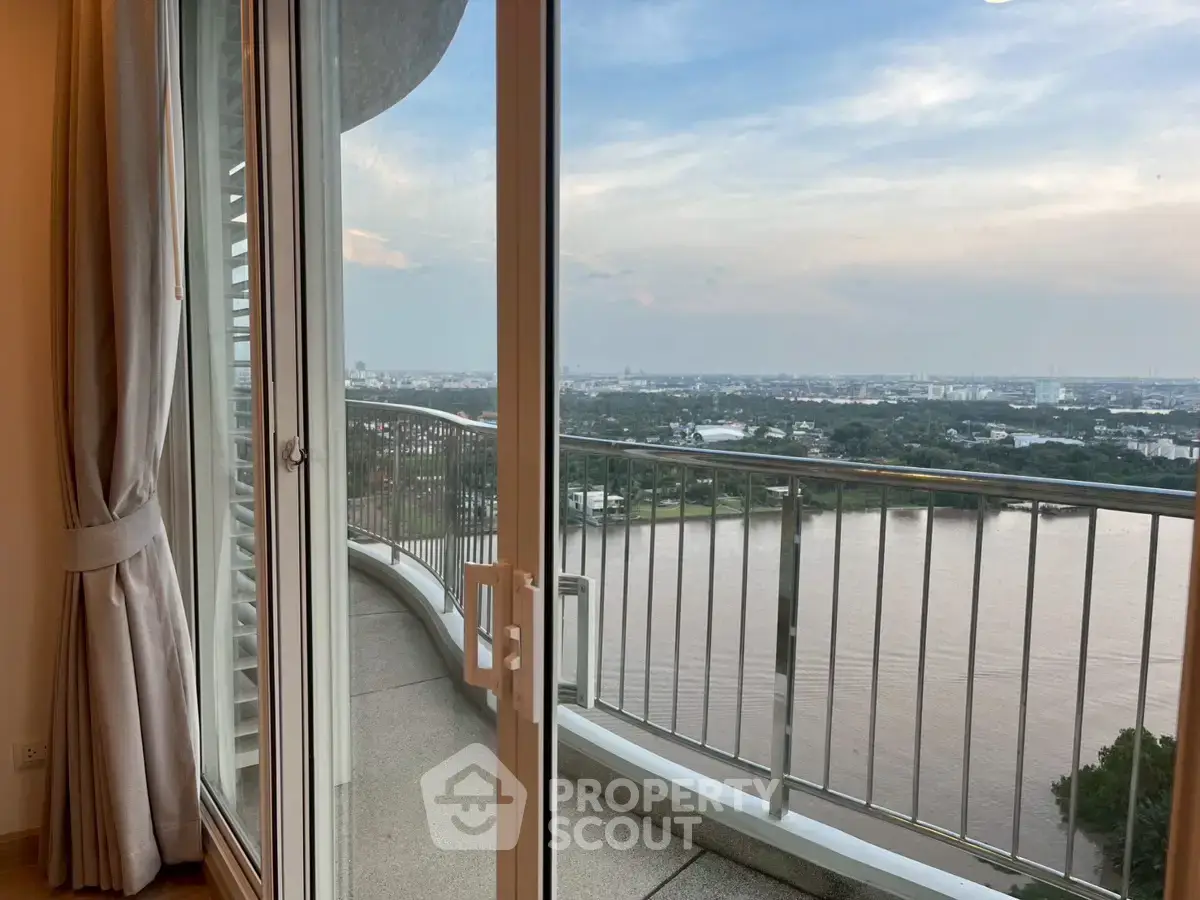 Stunning river view from a high-rise balcony with glass doors, perfect for serene living.