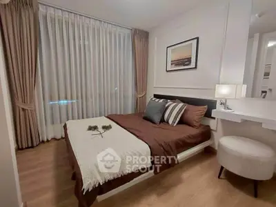 Cozy modern bedroom with elegant decor and large window for natural light.