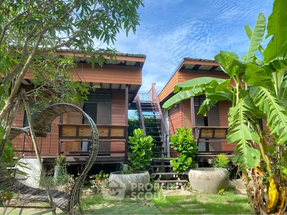 Charming wooden bungalows surrounded by lush greenery and tropical plants, perfect for a serene getaway.