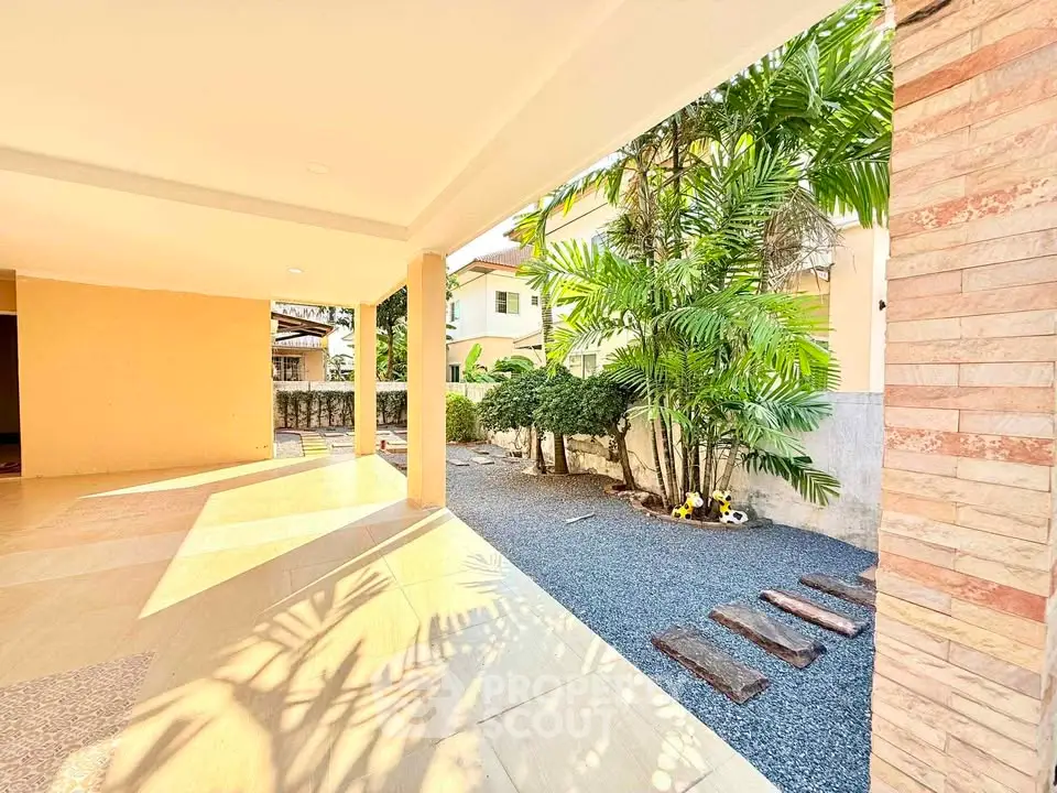 Spacious covered patio with garden view and stepping stones
