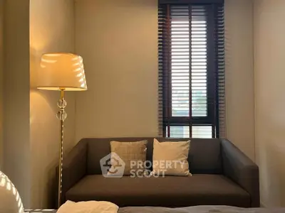 Cozy living room with modern sofa and stylish floor lamp near window with blinds.