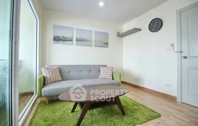 Modern living room with stylish sofa, green rug, and wall art in a cozy apartment.