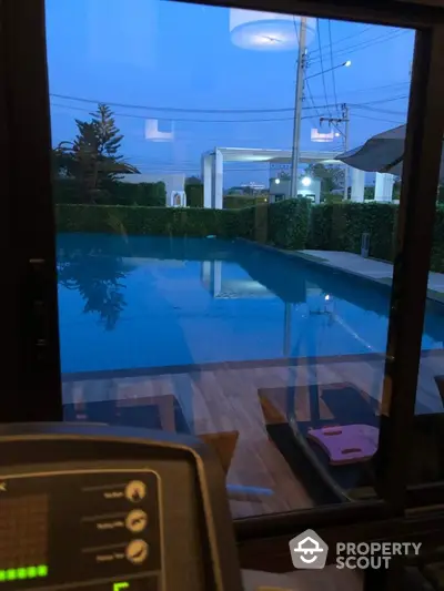 Luxurious pool view from modern gym with evening ambiance